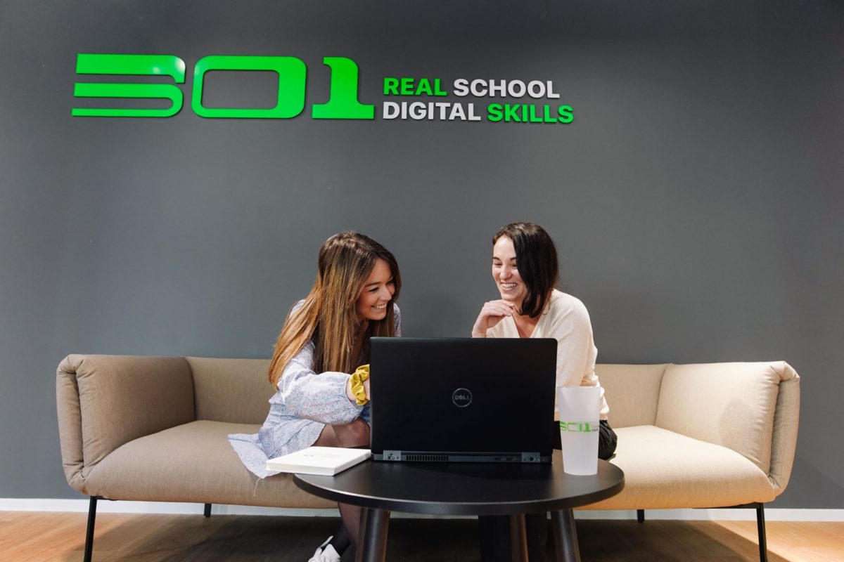 Deux étudiantes de l'école 301 assisent sur un canapé devant un ordinateur