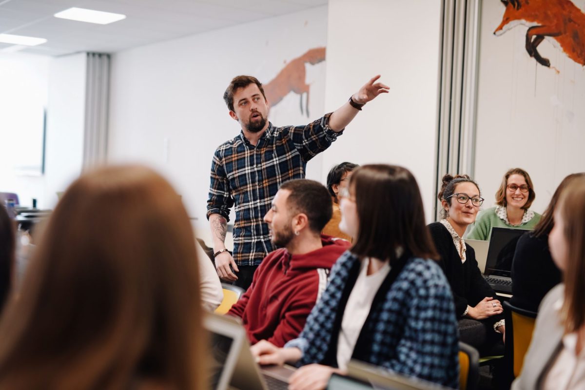 Un professeur pointe l'écran de la salle de la classe