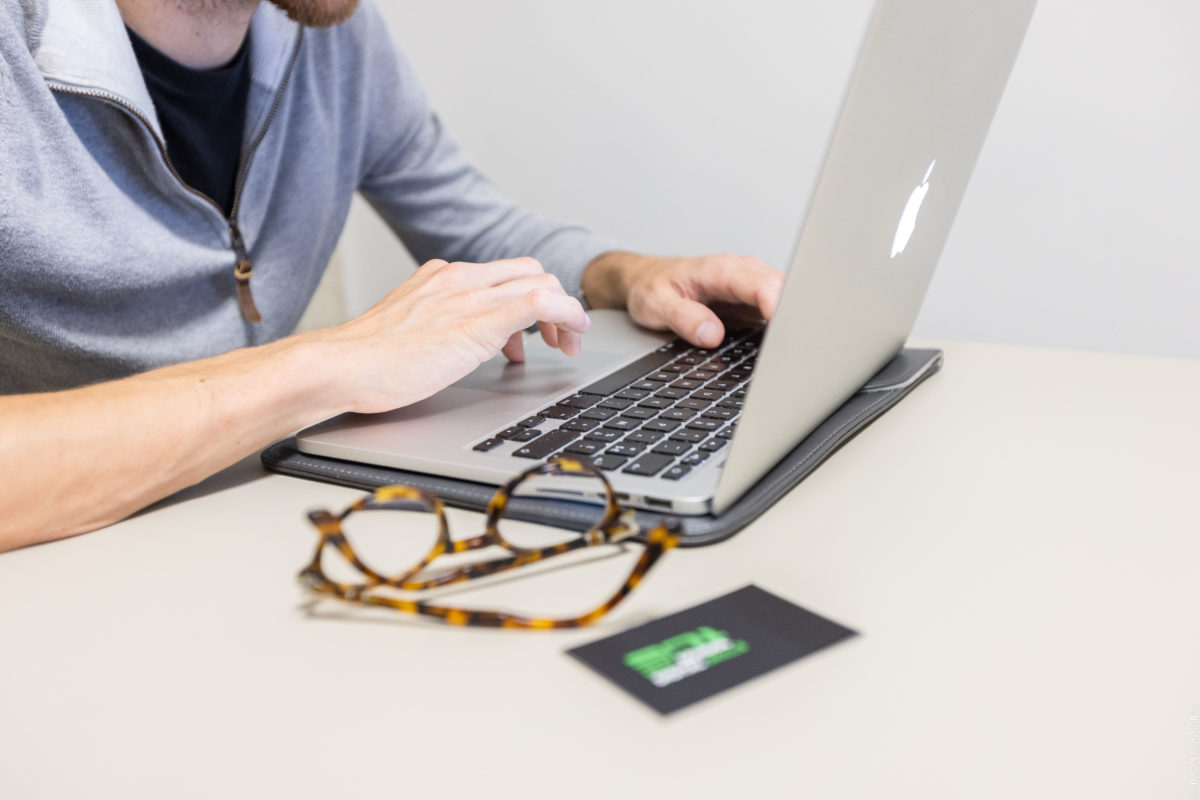 Un ordinateur portable et des lunettes posées sur un bureau