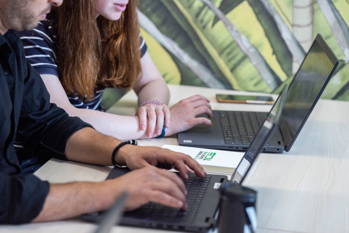 Deux personnes travaillent sur leur ordinateur portable dans une salle de classe de l'école 301 Rennes