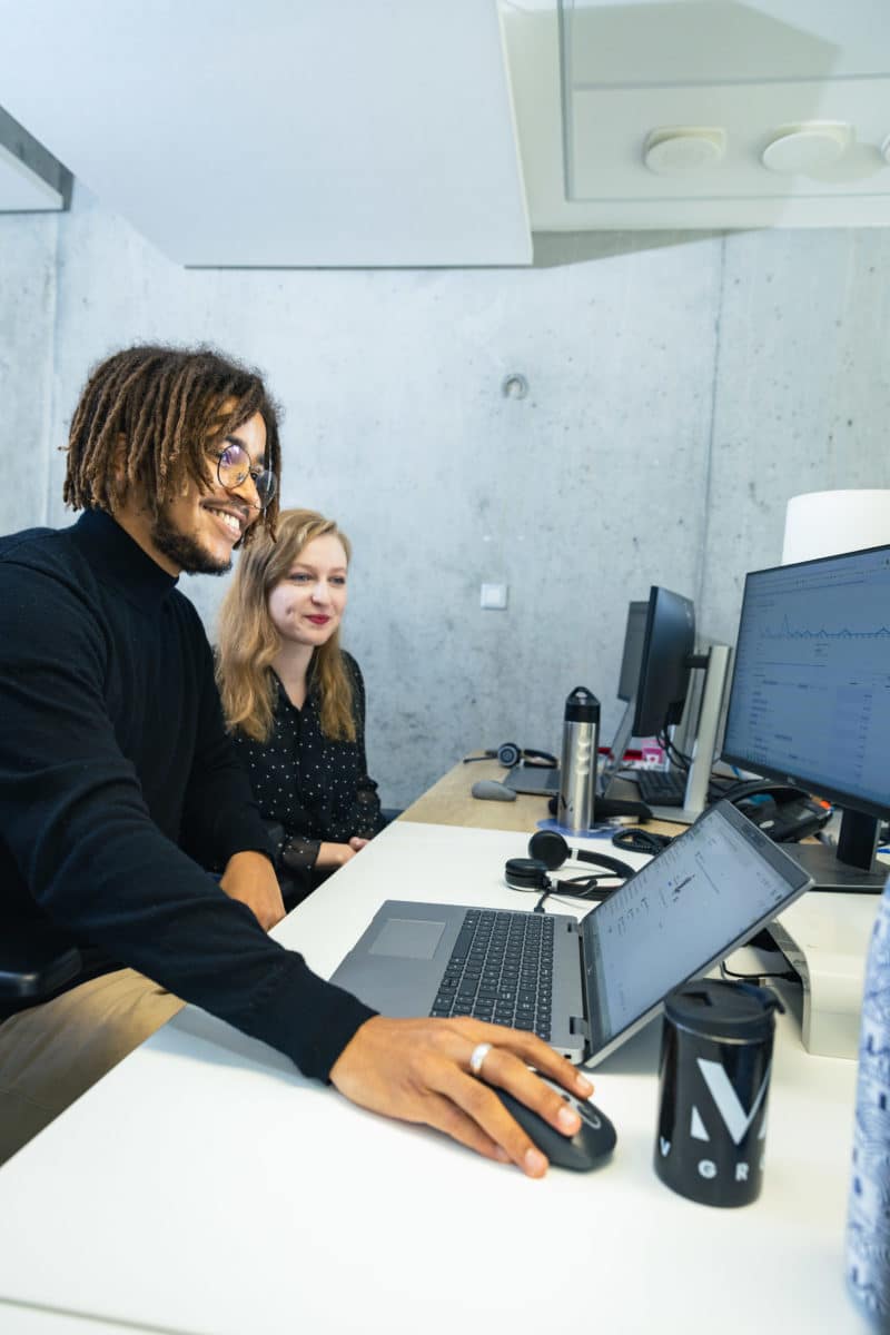 Deux personnes devant un ordinateur dans un bureau